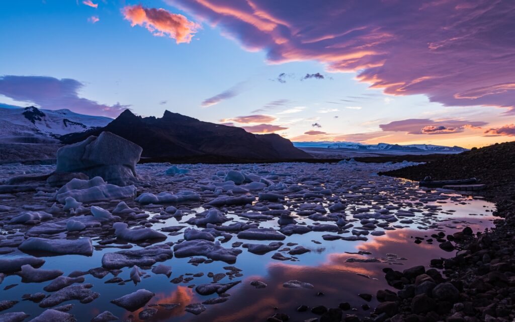 Glassy iceberg-dotted lagoon at sunset in Iceland