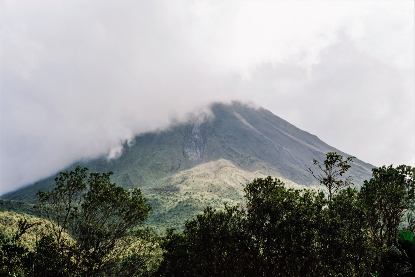 Arenal Volcano partially covered by low hanging clouds in Costa Rica