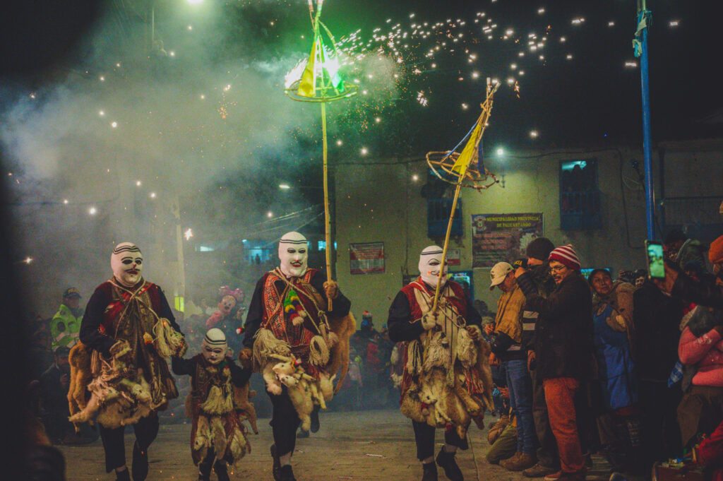 Group of costumed traditional dancers parading through the streets of Paucartambo during Virgen del Carmen Festival in Peru